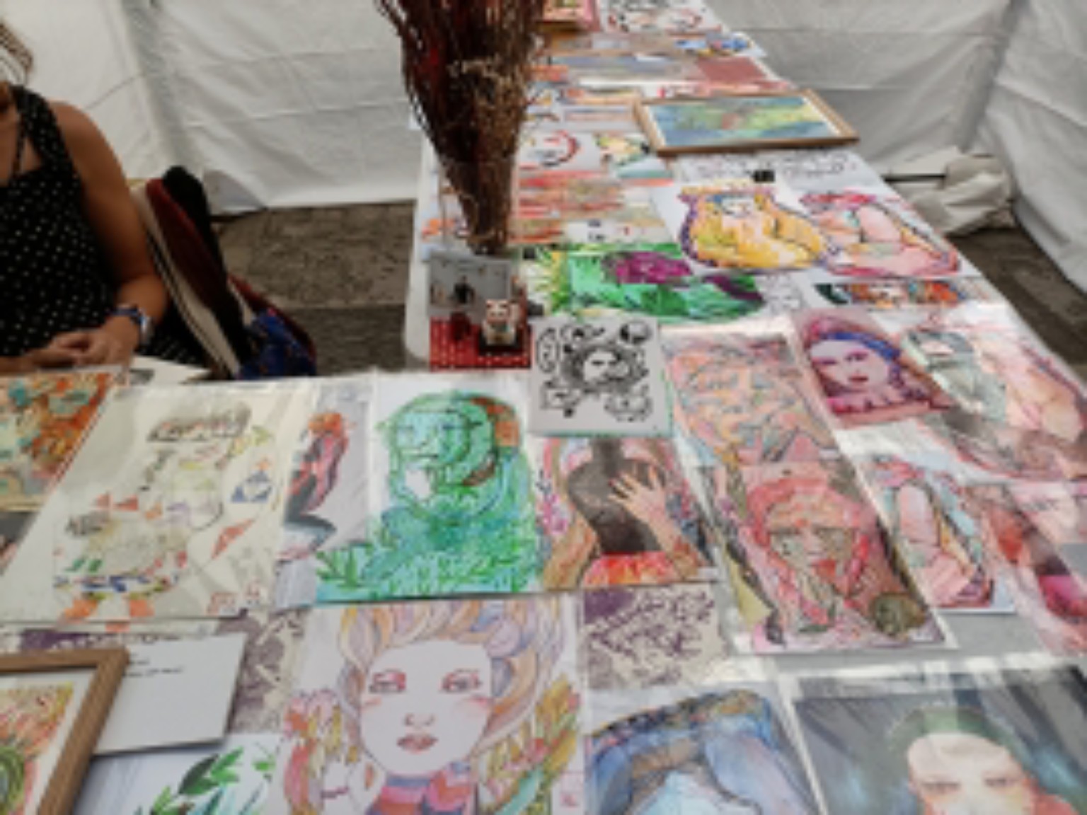 A display table covered with drawings, paintings and reproductions.